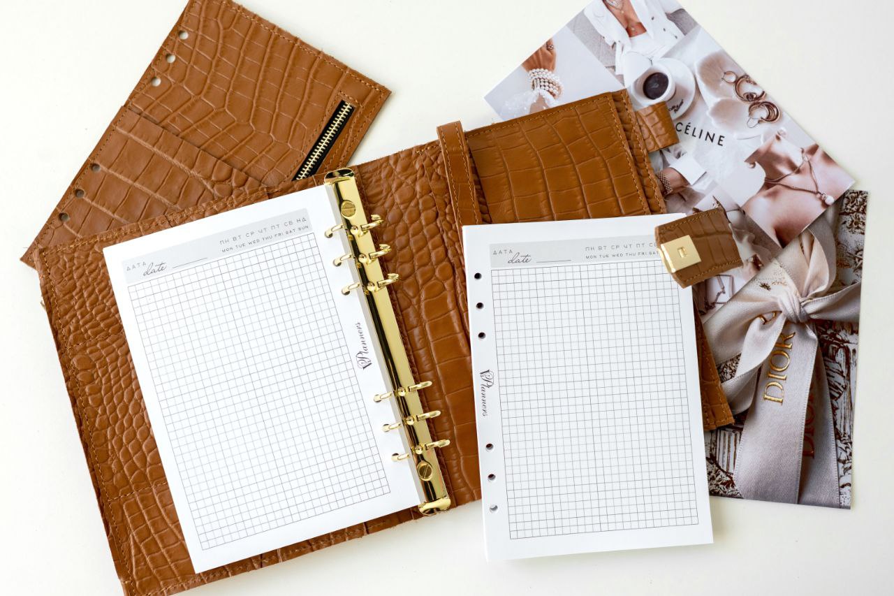 Rare brown leather A5 notebook cover with big binder rings and grid pages on display.