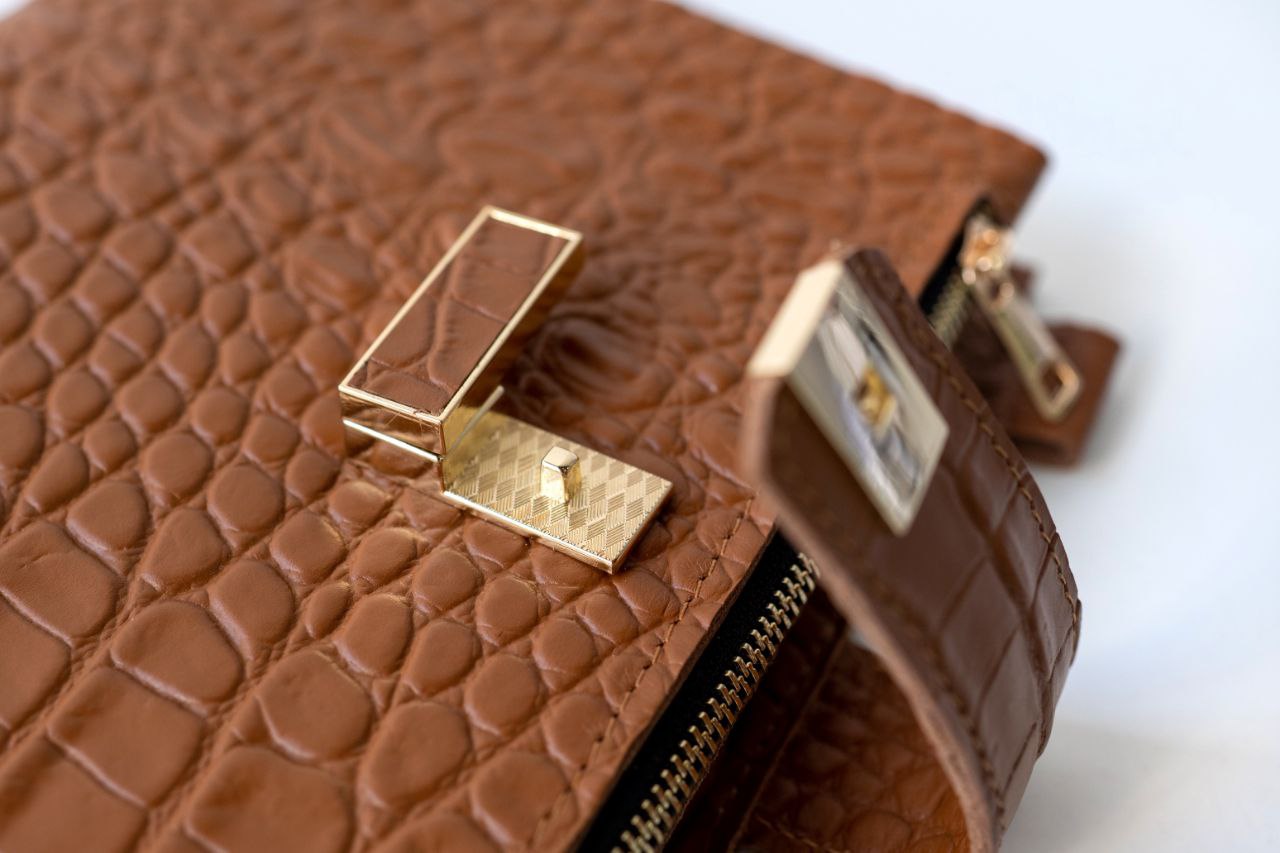 Close-up of rare brown leather notebook cover with gold clasp details.